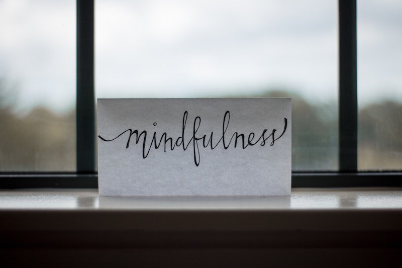 Photo of a card on a windowsill that says "mindfulness"