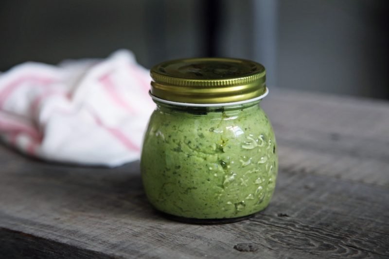 Basil Pesto: Photo  of a canning jar of pesto on a rustic wood tabletop