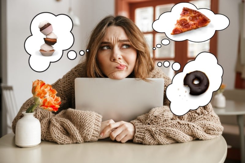 One of the questions people often get when they start intuitive eating is "aren't you worried about what giving up will do to you health?" Photo of young woman wearing a baggy tan cable knit sweater hugging her laptop with thought bubbles containing images of pizza, doughnuts and cupcakes around her head.