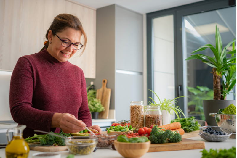 Woman experimenting with making a nourishing meal instead of engaging in self-sabotage by ordering takeout.